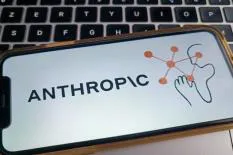 Mobile phone displaying the AnthropiC logo, featuring a graphic of a hand interacting with connected nodes.