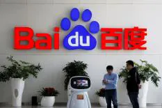 Baidu office signage with the logo and two employees interacting in front of a plant.